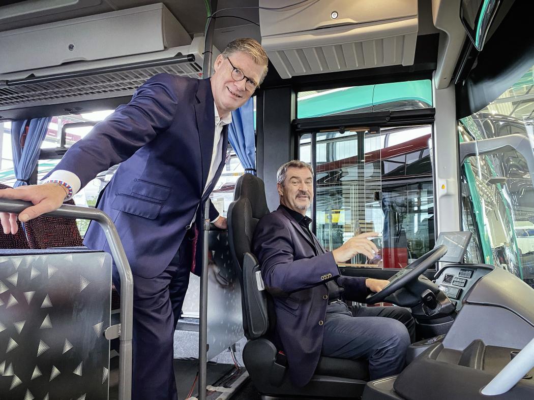 Dr. Markus Söder, Ministerpräsident des Freistaats Bayern (r.), am Steuer des Mercedes-Benz eIntouro. Links Till Oberwörder, CEO von Daimler Buses. (Foto: Daimler Truck AG)