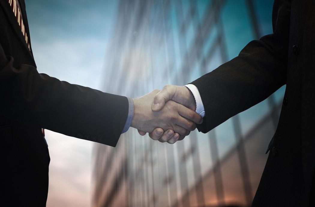„Partnerschaft im Fokus: Ein Handschlag zwischen zwei Geschäftsleuten symbolisiert die Zusammenarbeit in der Logistikbranche – doch das Bundestariftreuegesetz stellt neue Herausforderungen an diese Partnerschaften. (Foto: Pixabay)