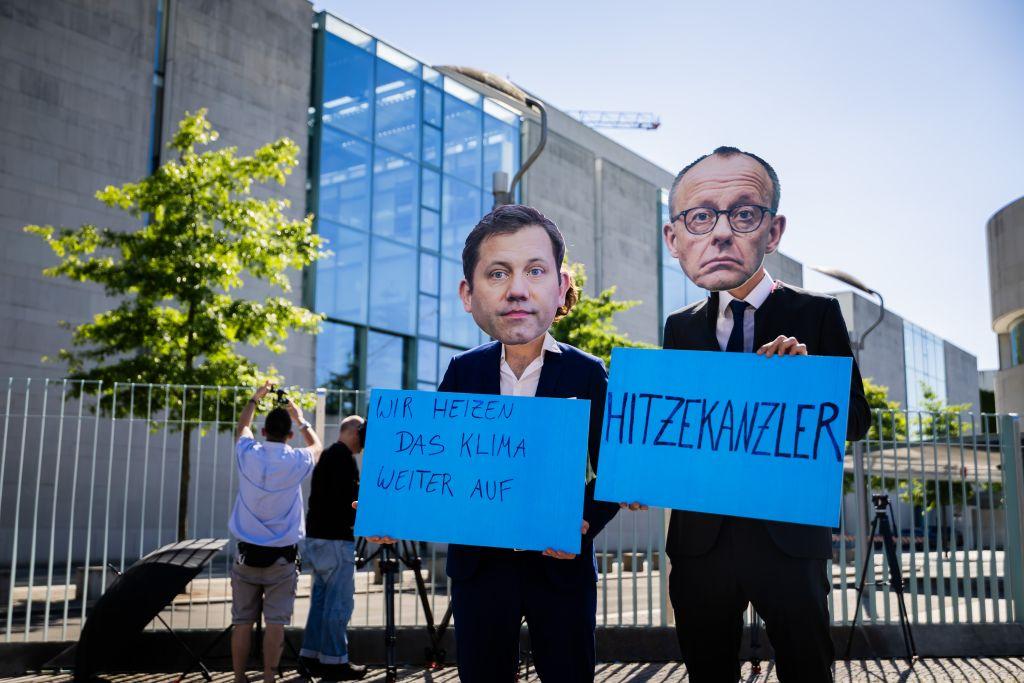 Klimaschutz ade? Aktivisten einer NGO für ein klimaneutrales Deutschland protestieren mit Masken, die die Gesichter des Bundeskanzlers und Bundesfinanzministers zeigen, vor dem Bundeskanzleramt vor dem Koalitionsausschuss. Die Stromsteuer soll nun doch nicht sinken. | Foto: Christoph Soeder/dpa