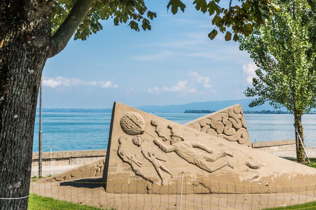 Sandskulptur am Bodenseeufer: Kunstteams interpretieren das Festivalthema „Natural Intelligence“ mit figürlichen Darstellungen. | Foto: Mattias Nutt